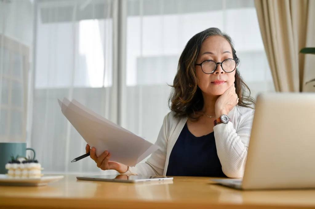 Woman reviewing mortgage documents online while at her desk.