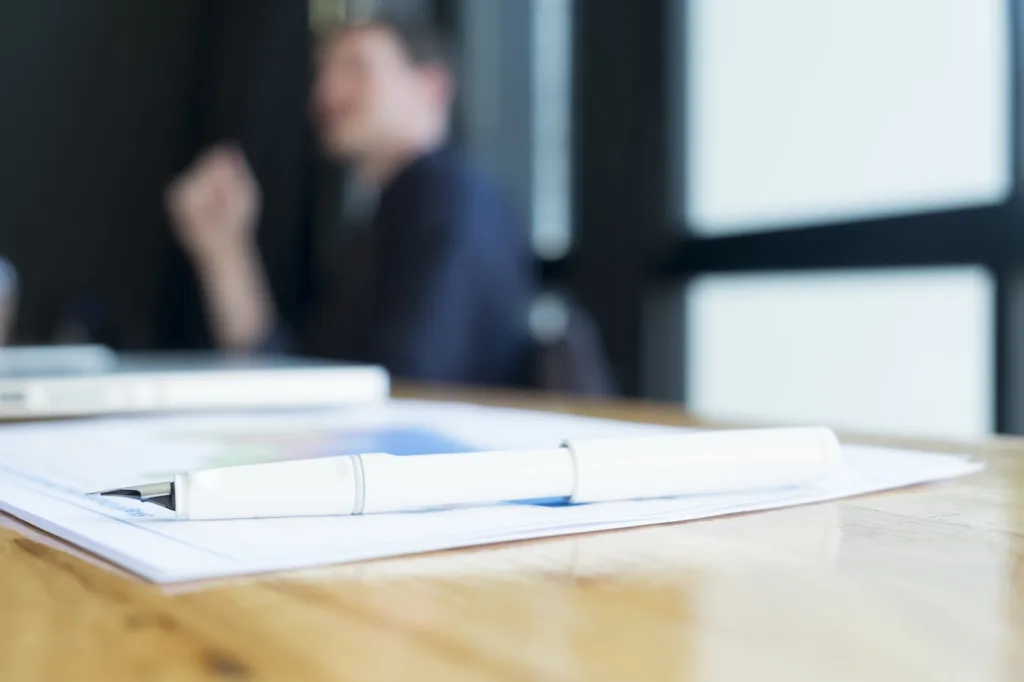 Divorce financial planning paperwork and pen on desk during home loan strategy meeting.