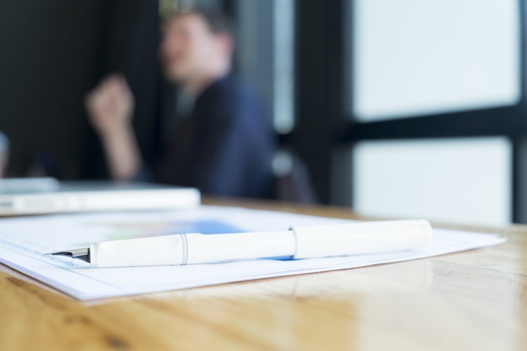 Divorce financial planning paperwork and pen on desk during home loan strategy meeting.